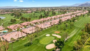 A golf course with a row of houses and a clear view of the surrounding landscape. - Woodhaven Great Views on the Golf Course (Palm Desert)