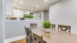 A dining area with a wooden table, four chairs, and a potted plant. - 5 Mi to Dtwn: Ukrainian Village Apartment! (Chicago)