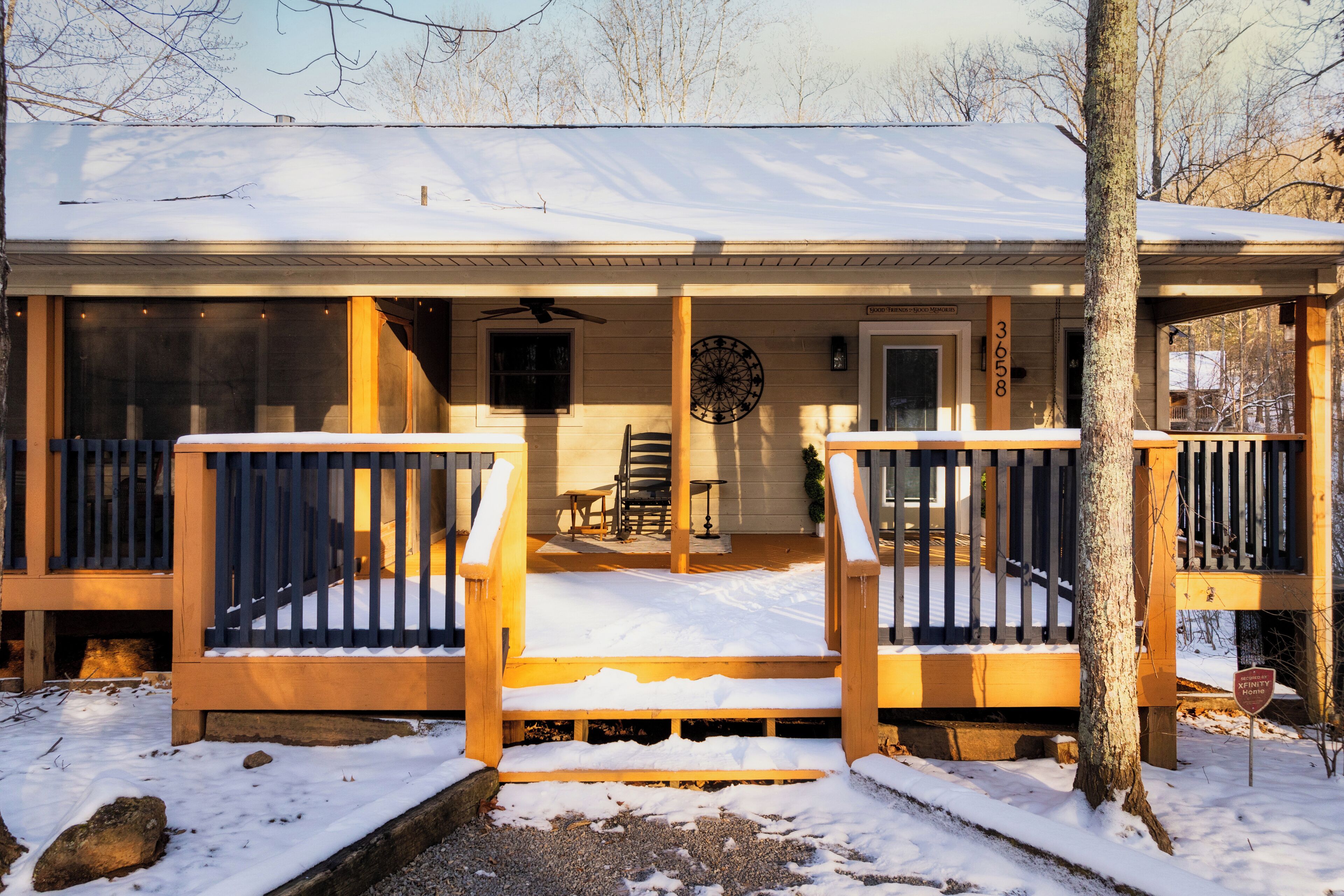 A wooden cabin with a covered porch, a dining area, and a snow-covered deck.