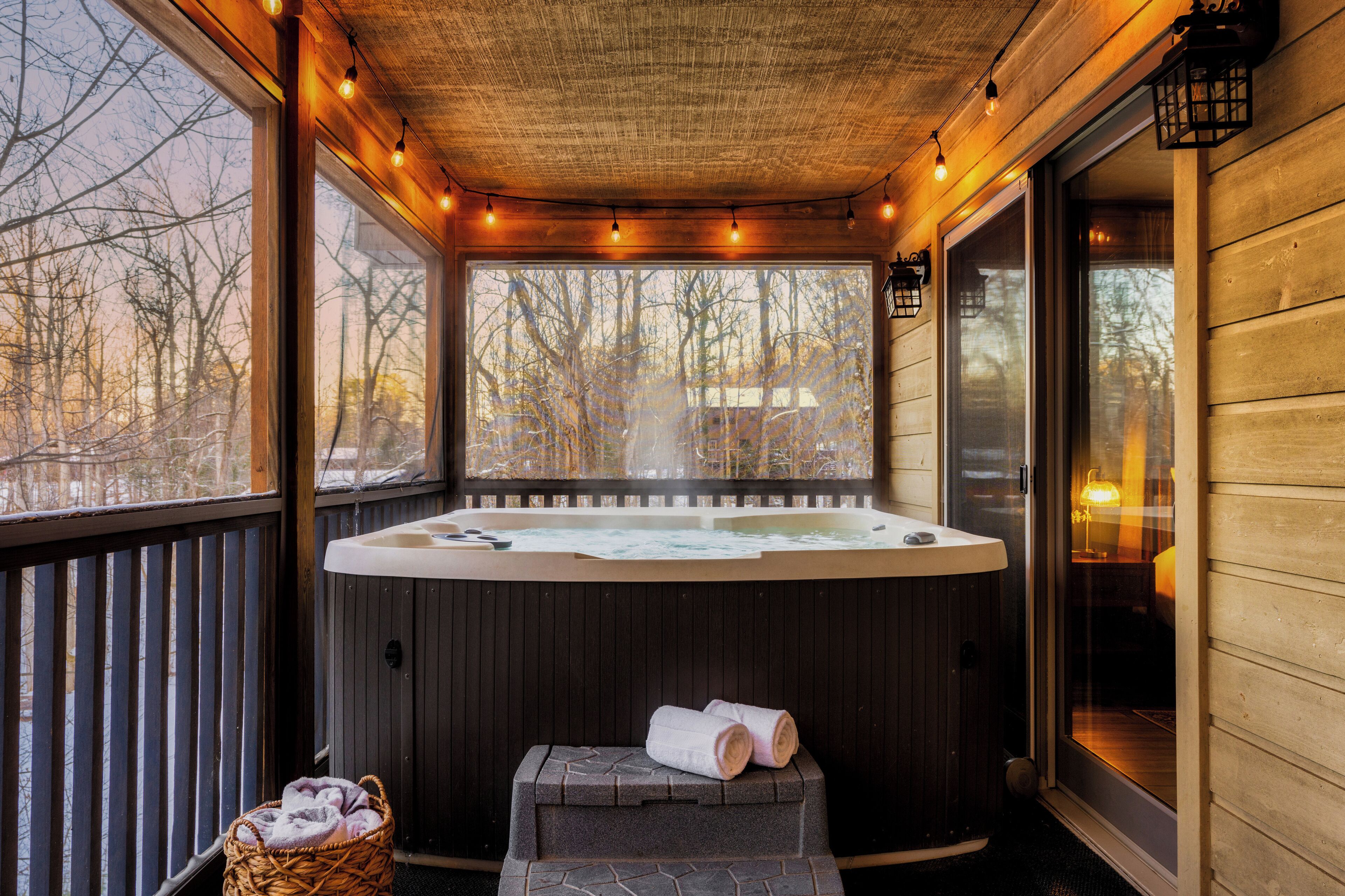 Un jacuzzi con cubierta de madera y vista a los árboles.