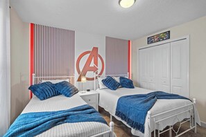 A bedroom with two beds, a large wall decoration, a closet, and a ceiling light.