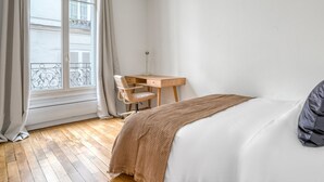 Une chambre à coucher avec un lit, un bureau et une chaise.