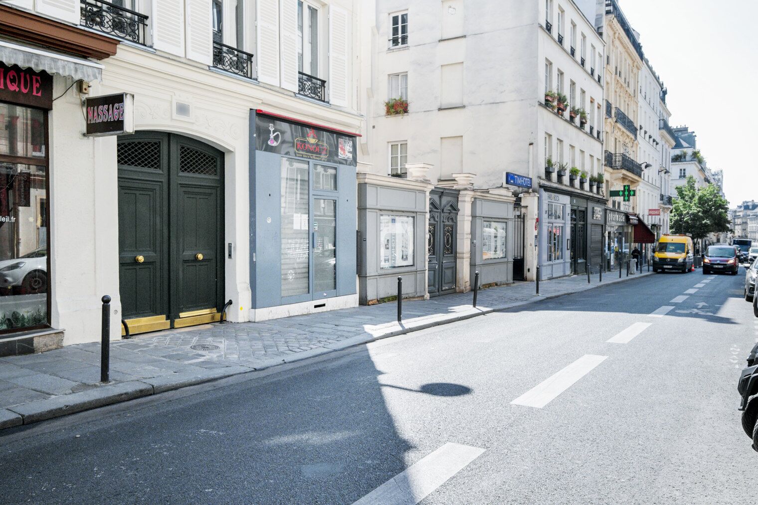 Une vue de rue avec un salon de massage, une boutique et un établissement Tim Hortons.