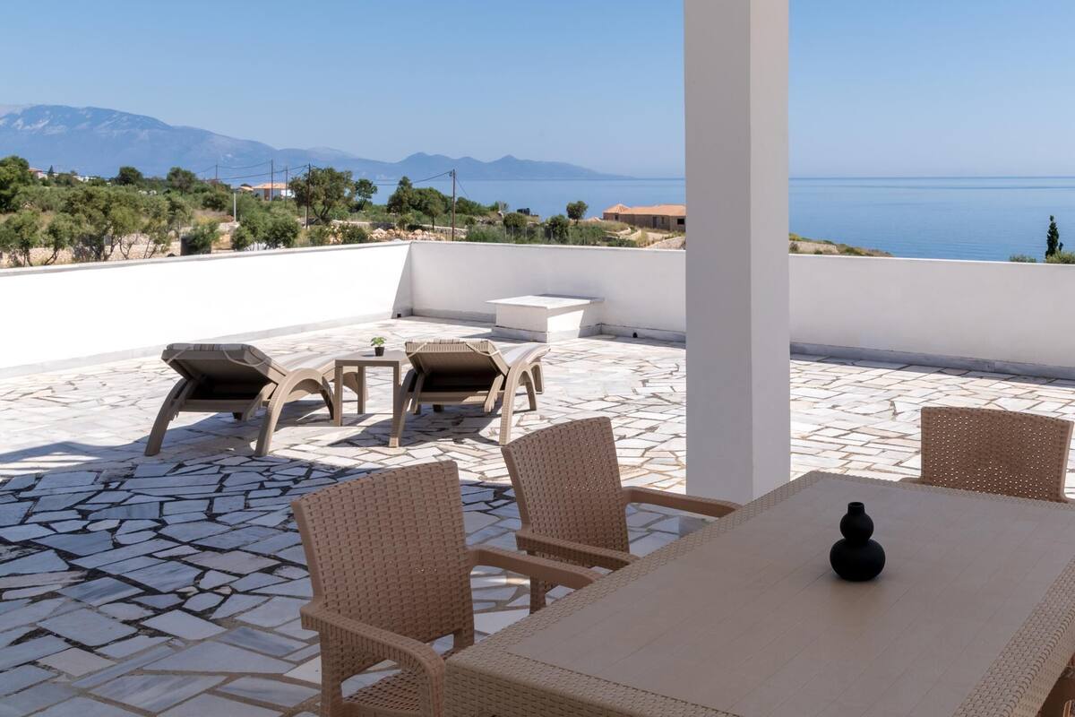A terrace with wicker furniture, a table, and a vase.