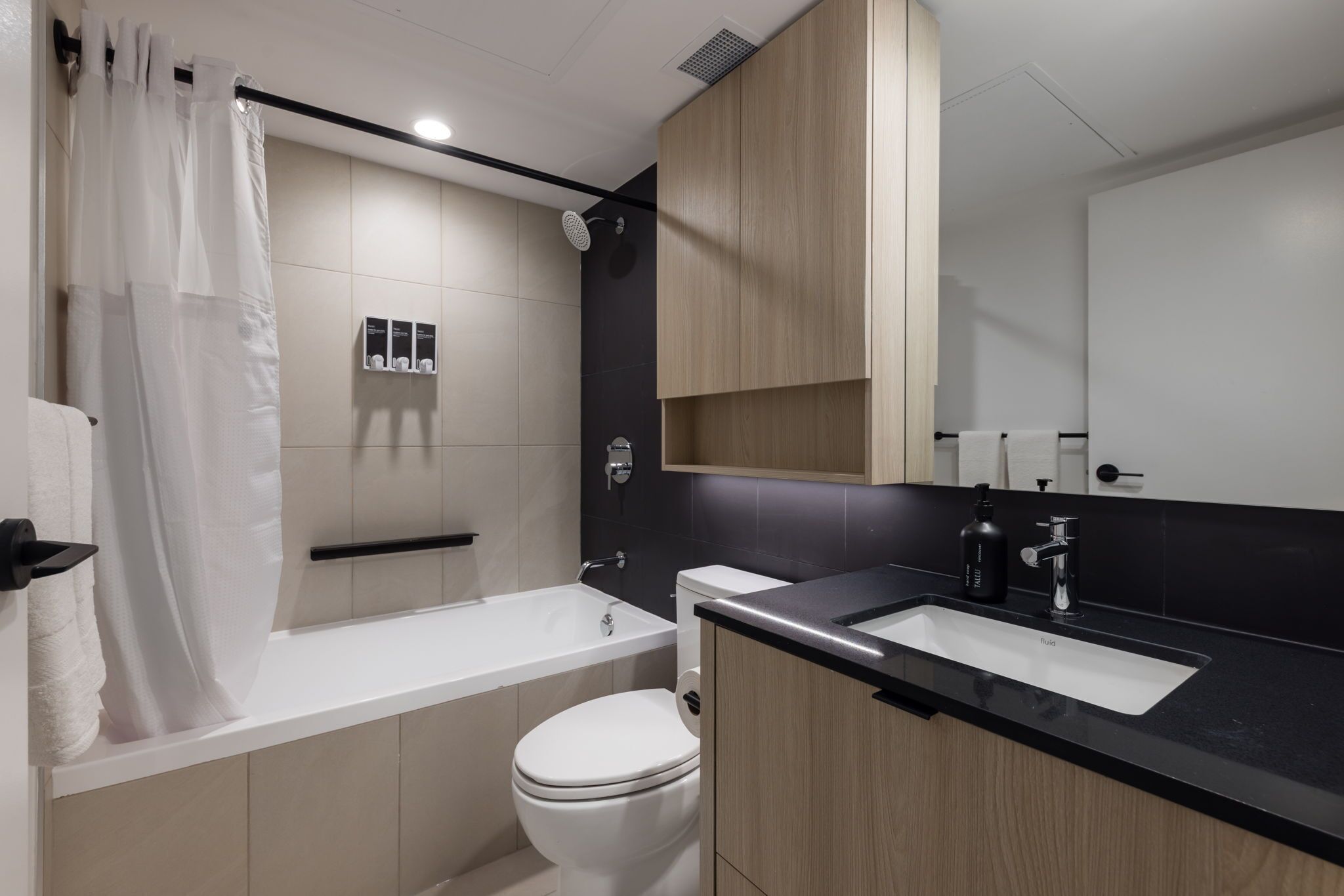A modern bathroom with a bathtub, toilet, and sink.