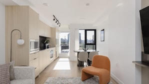 A modern living room with a sofa, a coffee table, and a dining area with chairs and a table. - Keefer House (Vancouver)