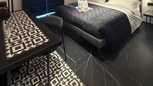 A modern bedroom with a large bed, a desk, and a wardrobe. - Volta 70 (Naples)