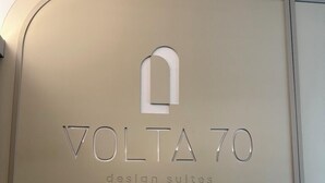 A sign with the text "VOLTA 70 design suites". - Volta 70 (Naples)