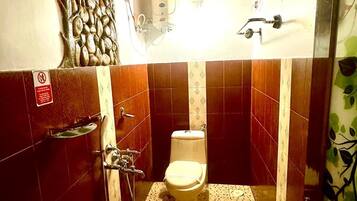A small bathroom with a toilet, sink, and shower.