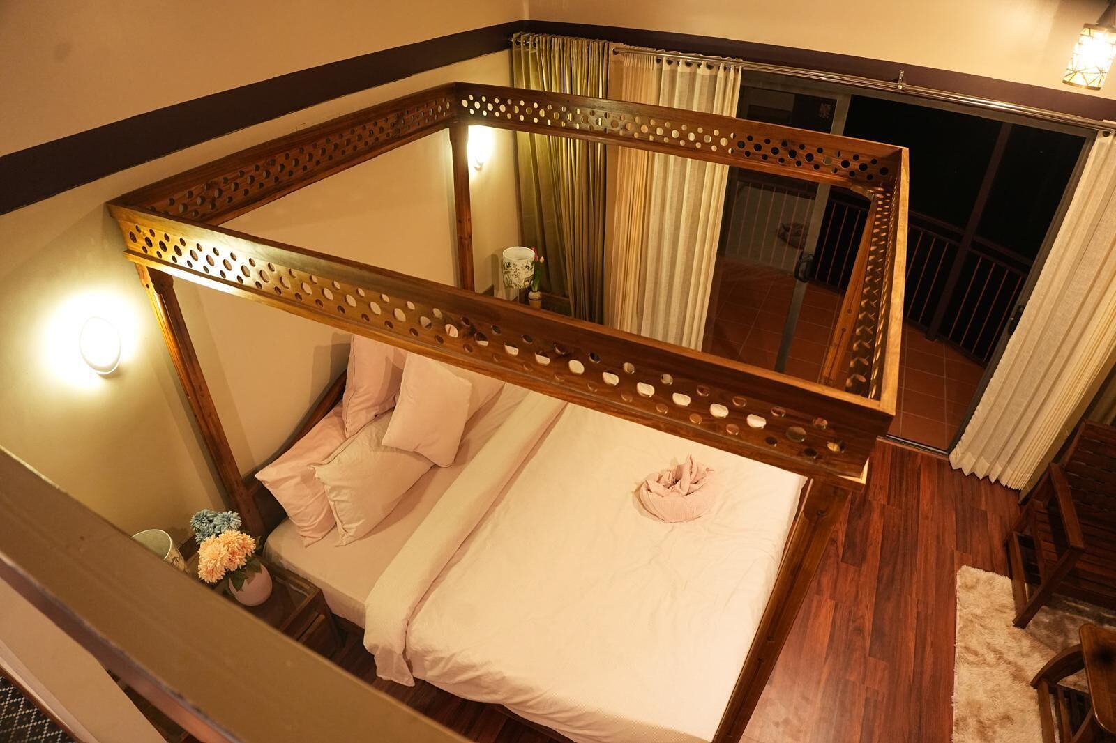 A four-poster bed with a wooden frame and a mirror.
