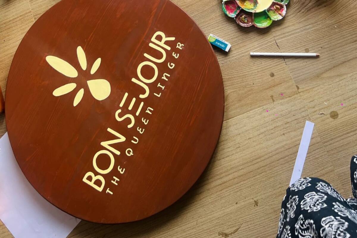 A wooden table with framed name signs and a circular sign with text.