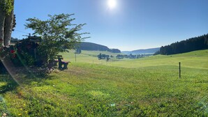 Paisaje rural con cielo despejado, un banco y una señalizadora.