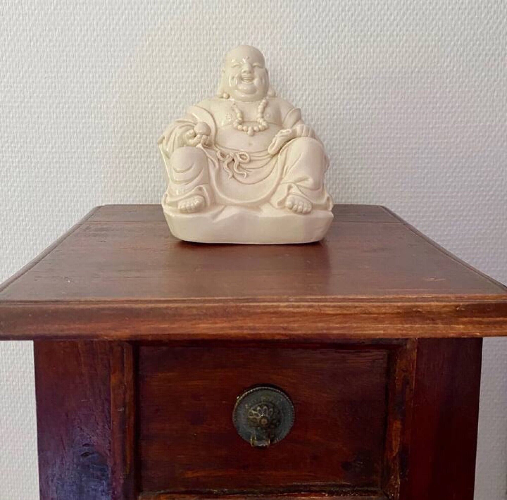 Una mesa de madera con una estatua tallada de una figura sentada.