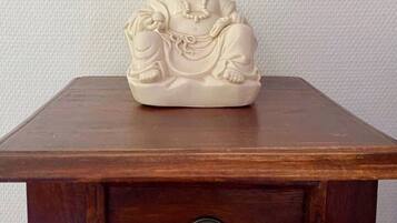 Una mesa de madera con una estatua tallada de una figura sentada.