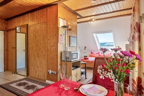 Interior de madera con una mesa de comedor preparada, un microondas y una ventana con vistas.