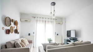Una sala moderna con un sofá, un televisor y adornos en la pared.