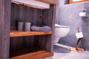 A bathroom with a wooden vanity, a toilet, and a towel rack. - Apartment 'Wiagsog' with Mountain View, Balcony and Wi-Fi (Garmisch-Partenkirchen)