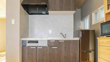 A modern kitchen with wood cabinets, a stainless steel sink, and a built-in dishwasher.