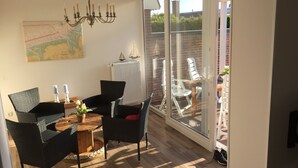 A dining area with a table, chairs, and a chandelier. - Holiday Home 'In Strandnähe' with Private Terrace, Private Garden and Wi-Fi (Dornum)