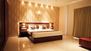 Un dormitorio moderno con una cama grande, cabecera de madera y pared con estampado.