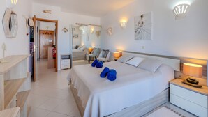 A modern bedroom with a large bed, bedside tables, a wardrobe, and a bathroom visible through an open door. - Sol Beach View Terrace by Interhome (Ferragudo)