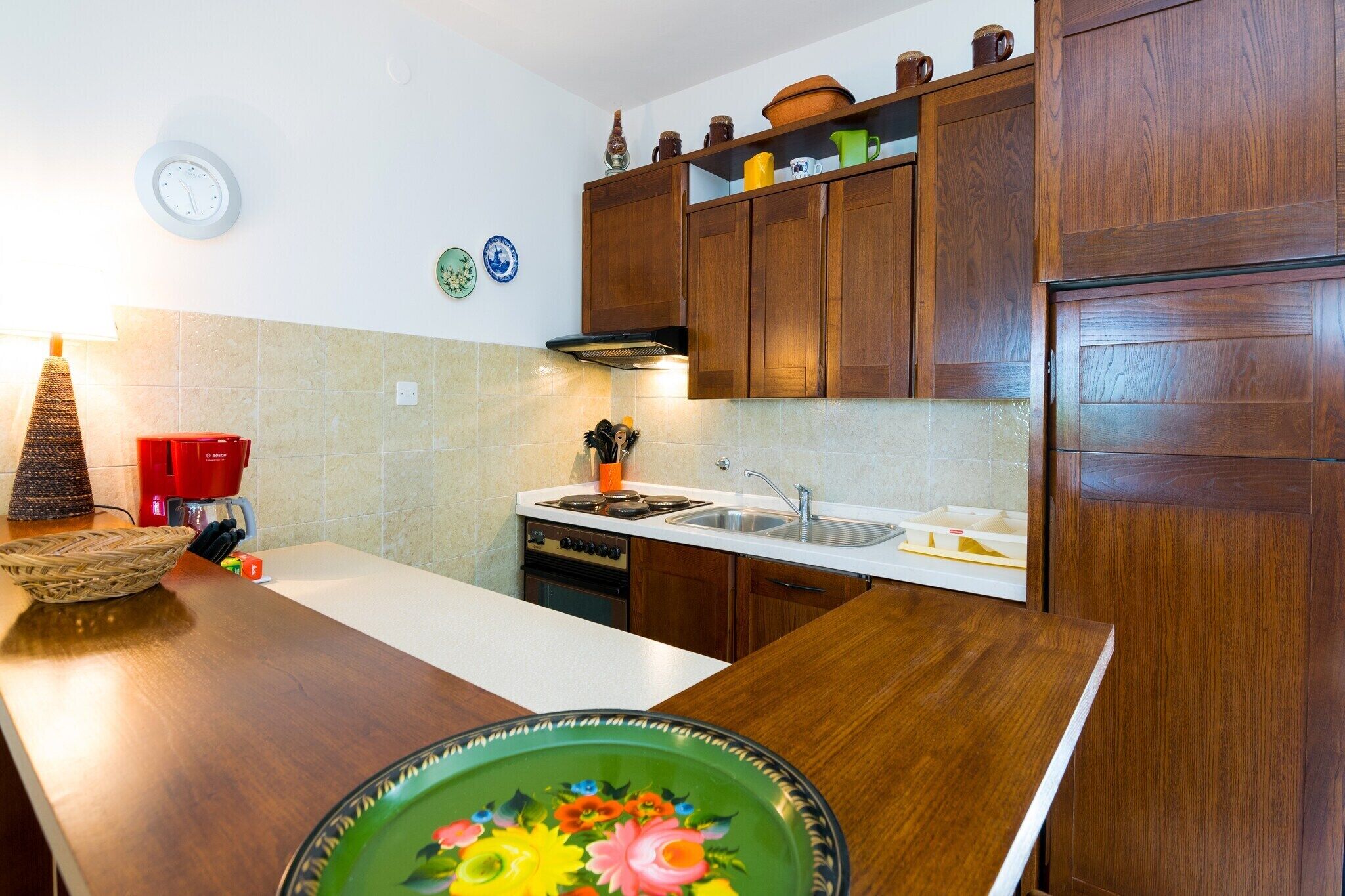 A kitchen with wooden cabinets, a stove, and a sink.