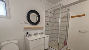 A bathroom with a toilet, sink, mirror, shower, and a wooden shelf. - 15 mins to Airport|Gateway to NSW (Campbellfield)
