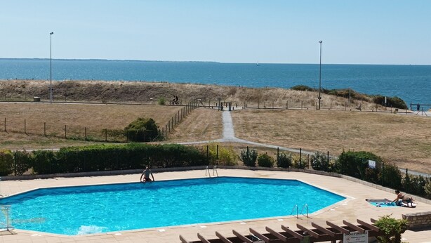 A swimming pool with a view of the sea and a fenced path leading to it. - Large 2-bedroom apartment with sea and pool views. Beach 40 meters away. (damgan)