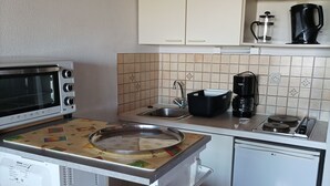 A compact kitchen with a microwave, coffee maker, and dishwasher. - Large 2-bedroom apartment with sea and pool views. Beach 40 meters away. (damgan)