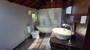 Ein kleines Badezimmer mit Toilette, einem großen Waschbecken und einer Dusche.