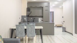 Una cocina moderna con armarios grises, una mesa de comedor con sillas y una pequeña isla.