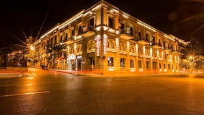 Un edificio histórico con un cartel de hotel visible, varios balcones y arquitectura clásica.