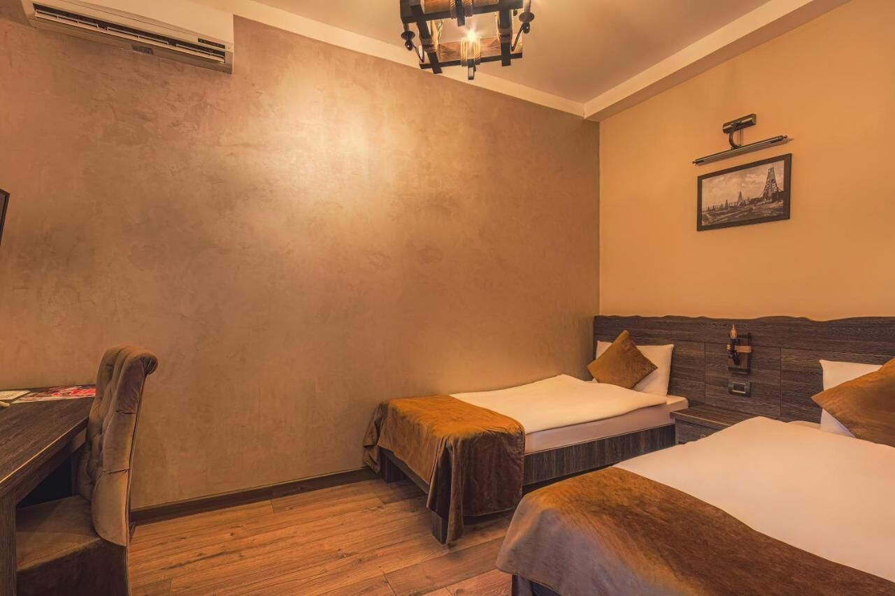 Une chambre d’hôtel avec deux lits, un bureau et une chaise.