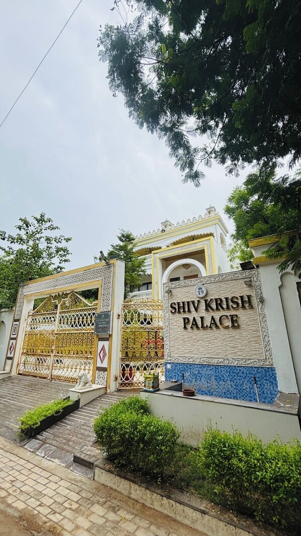 The entrance to Shiv Krish Palace with a decorative gate and a signboard. - Rates are per rooms for .two person and one kid  with roof top private pool. (Shela)