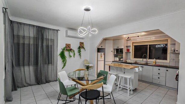 Een moderne keuken met witte kasten, een houten aanrechtblad en een inbouwoven.