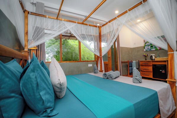 A room with a bed, a desk, and a window. - The jungle view (Mirissa)