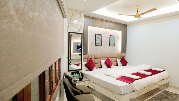 Quarto de hotel moderno com uma cama grande, uma escrivaninha e um ventilador de teto.