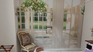 Une chambre à coucher avec un lit, une chaise et une fenêtre donnant sur une pelouse.
