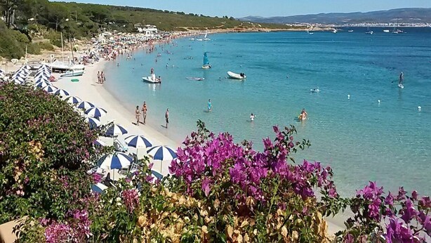 A beach with umbrellas, boats, and people. - Seaside comfort in the heart of Alghero (Alghero)