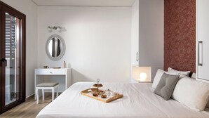 Ein ordentlich eingerichtetes Schlafzimmer mit Bett, Nachttisch und Schreibtisch mit Stuhl.