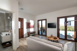 Villa superior, vista al mar | Área de sala de estar | Televisión de pantalla plana 