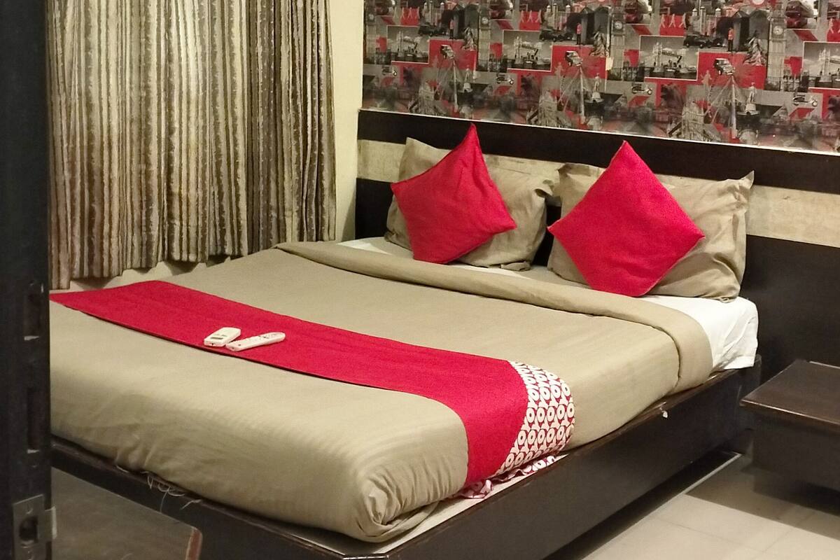 Un dormitorio con cama, cortinas, una pared con carteles y un equipo de aire acondicionado.