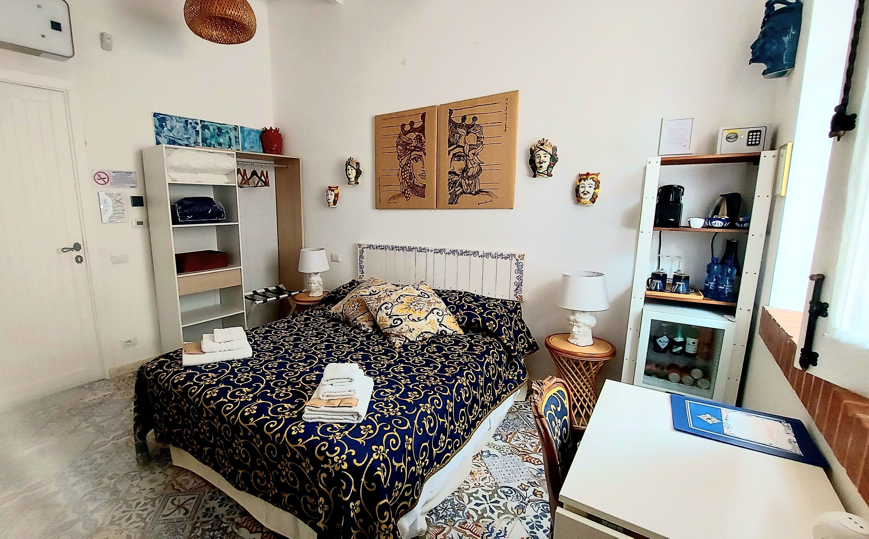 A neatly arranged bedroom with a bed, bedside tables, a wardrobe, and a small desk area.