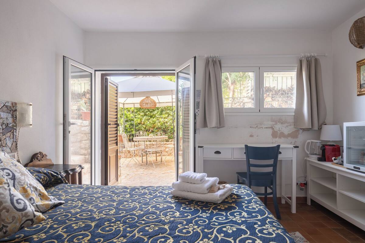 Ein Schlafzimmer mit Bett, Schreibtisch, Stuhl und Fernseher.