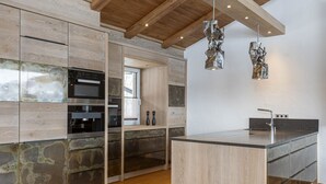 Una cocina moderna con armarios de madera, electrodomésticos de acero inoxidable y una isla central.