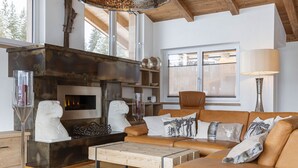 Una sala de estar moderna con chimenea, sofá de cuero y mesa de centro de madera.