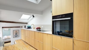 Eine moderne Küche mit Holzausstattung, einem eingebauten Backofen und einem Oberlicht.