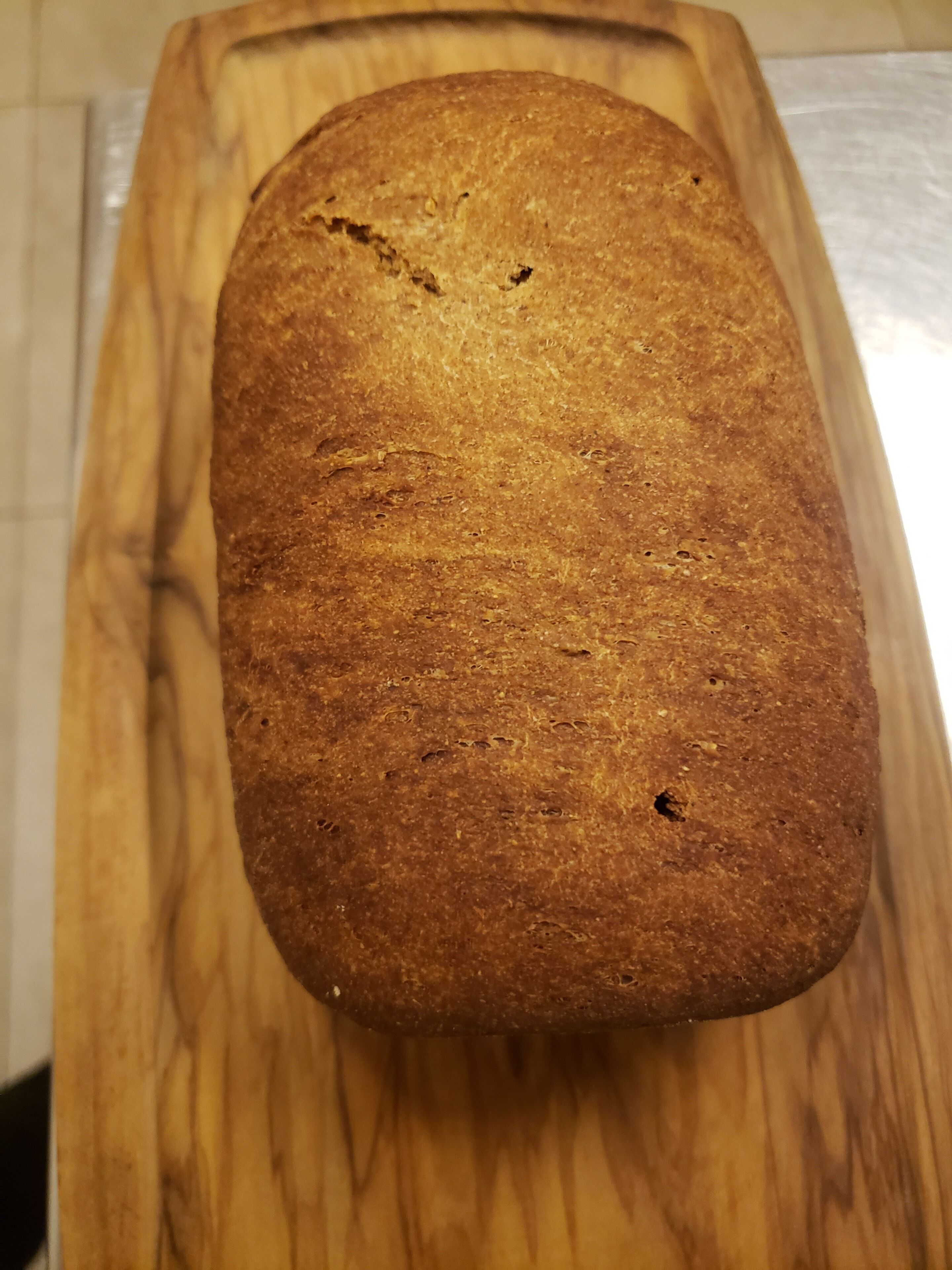 Una hogaza de pan sobre tabla de madera.
