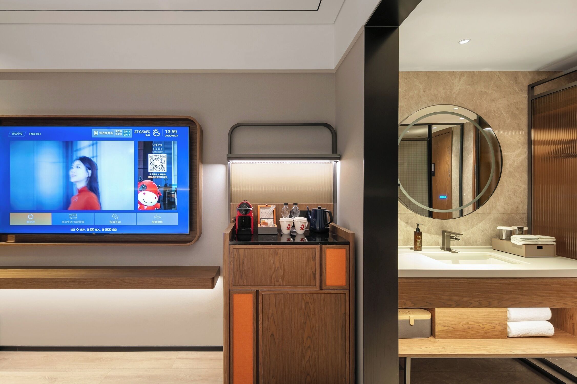 Een moderne badkamer met een televisie aan de muur die een programma toont, een houten wastafelmeubel met een spiegel en een wastafel.