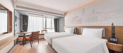 Habitación de hotel con dos camas, un escritorio, una silla y un mural en la pared.